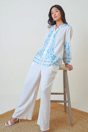 indigrey Luna white viscose shirt featuring blue floral Tatami embroidery on collar, sleeves, and hem worn by a model
