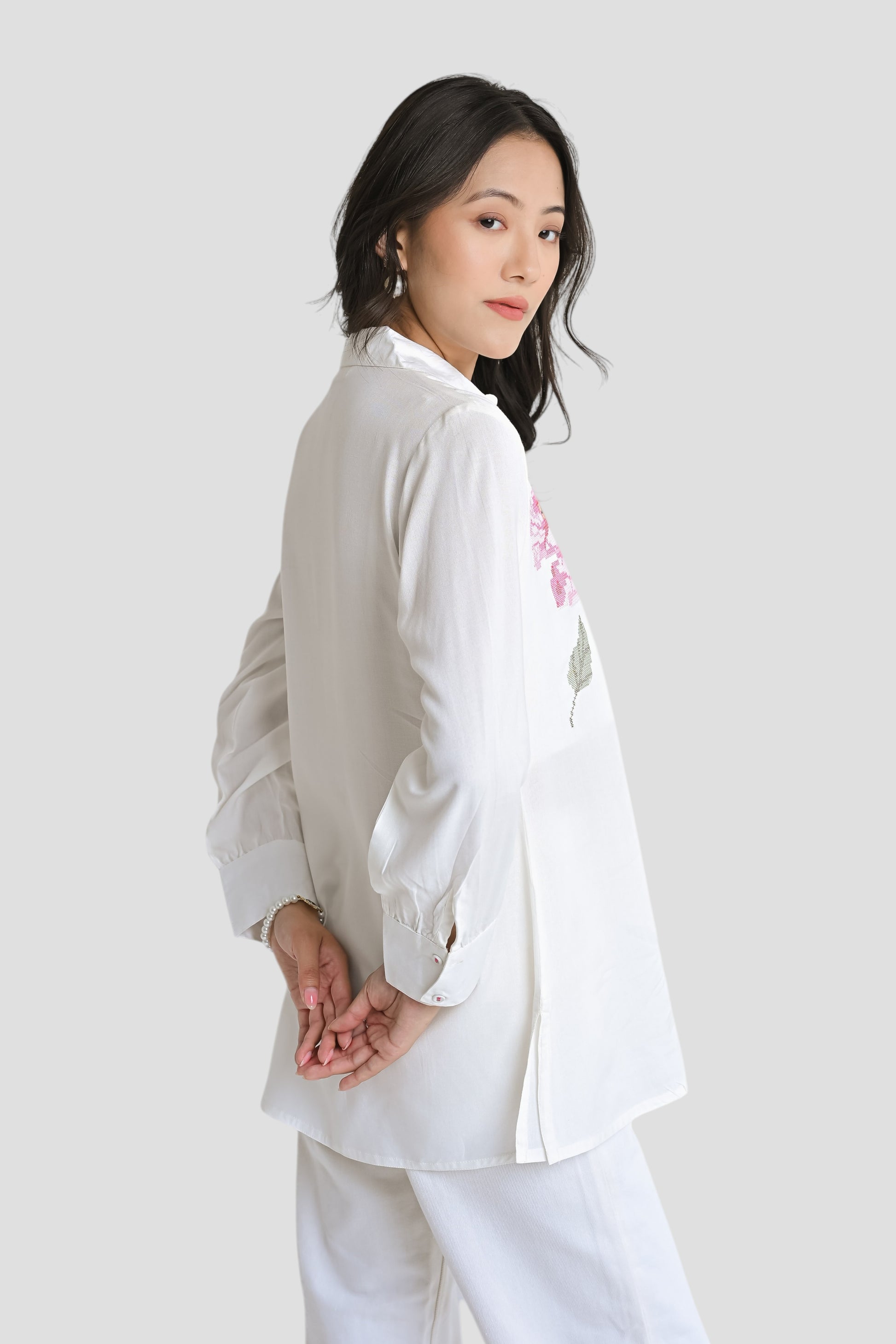 indigrey Ambrosia white shirt featuring delicate pixel cross stitch embroidery worn by a model in a side profile view