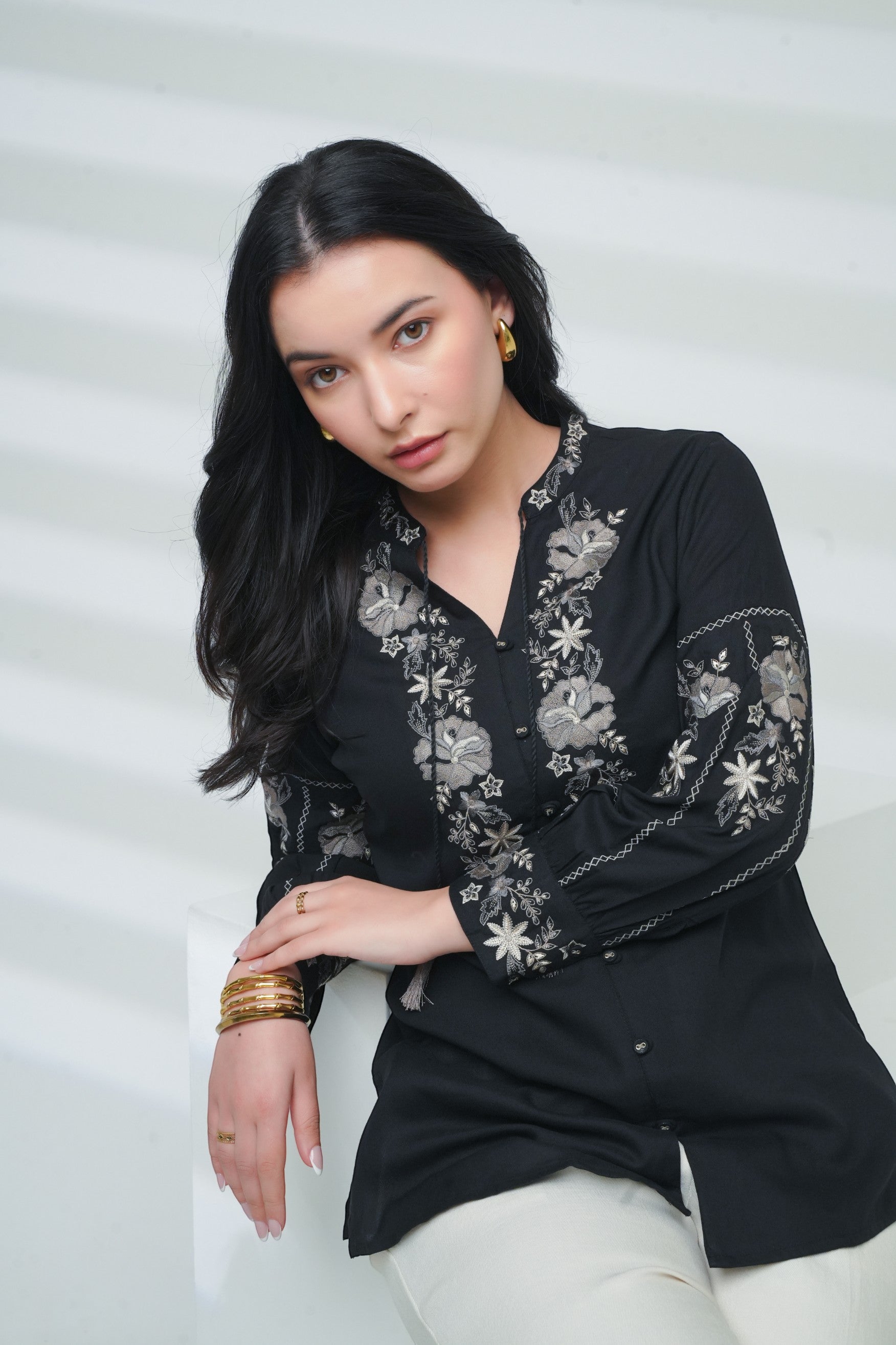indigrey black shirt featuring intricate floral embroidery on the neckline and sleeves worn by a woman