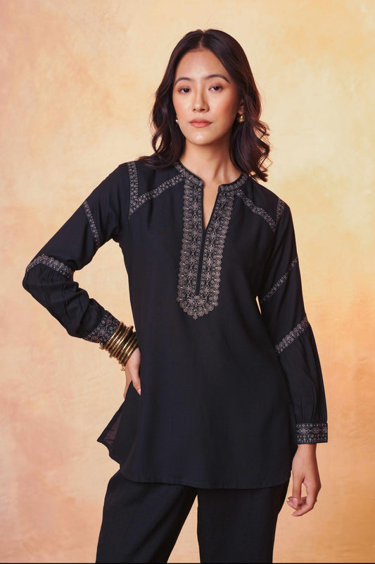 Model wearing indigrey black June top with tonal filigree traceline floral embroidery and long sleeves