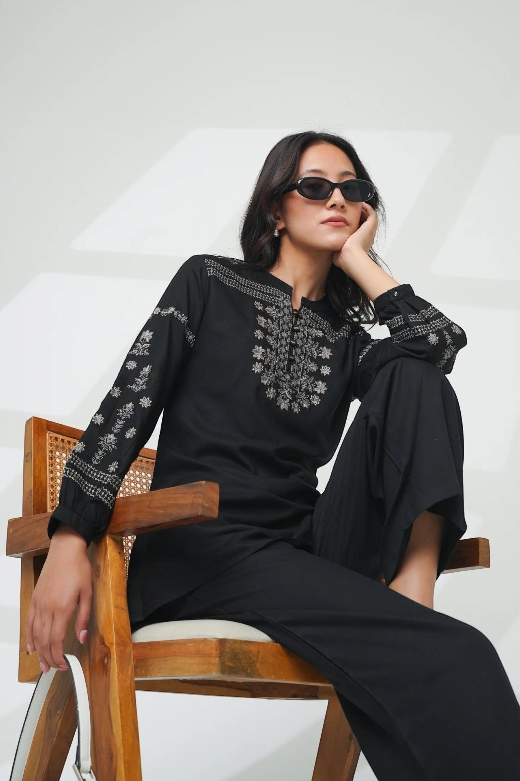 indigrey black straight-fit top with intricate white latticework embroidery, floral details, and gathered cuffs.