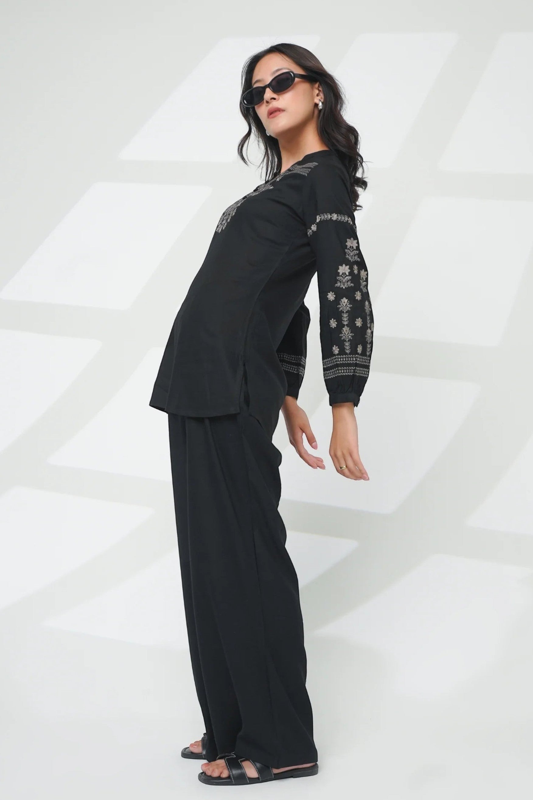 indigrey black straight-fit top with intricate latticework embroidery, floral details, and long sleeves on a model.