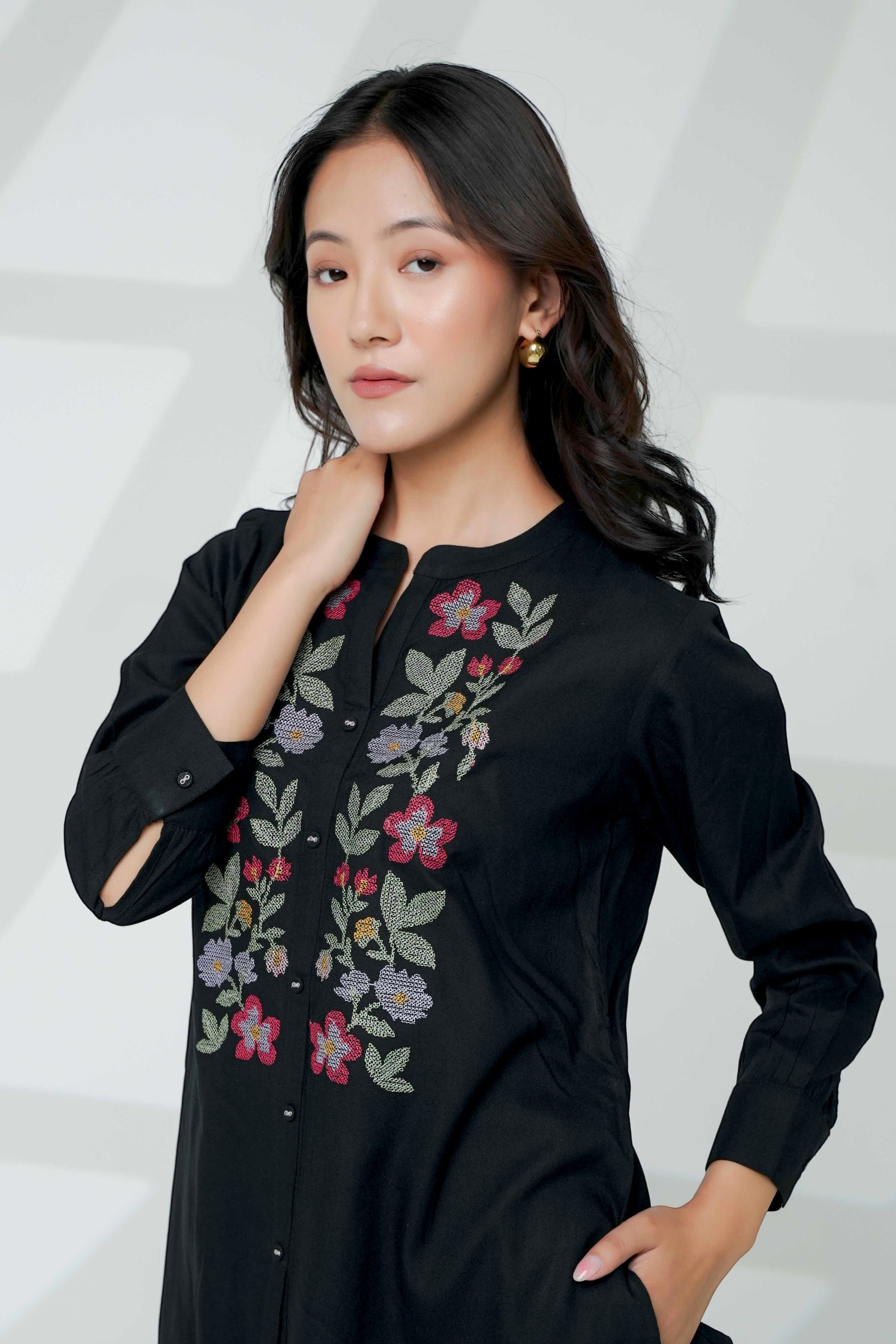 indigrey black shirt with handcrafted floral cross stitch embroidery worn by a woman