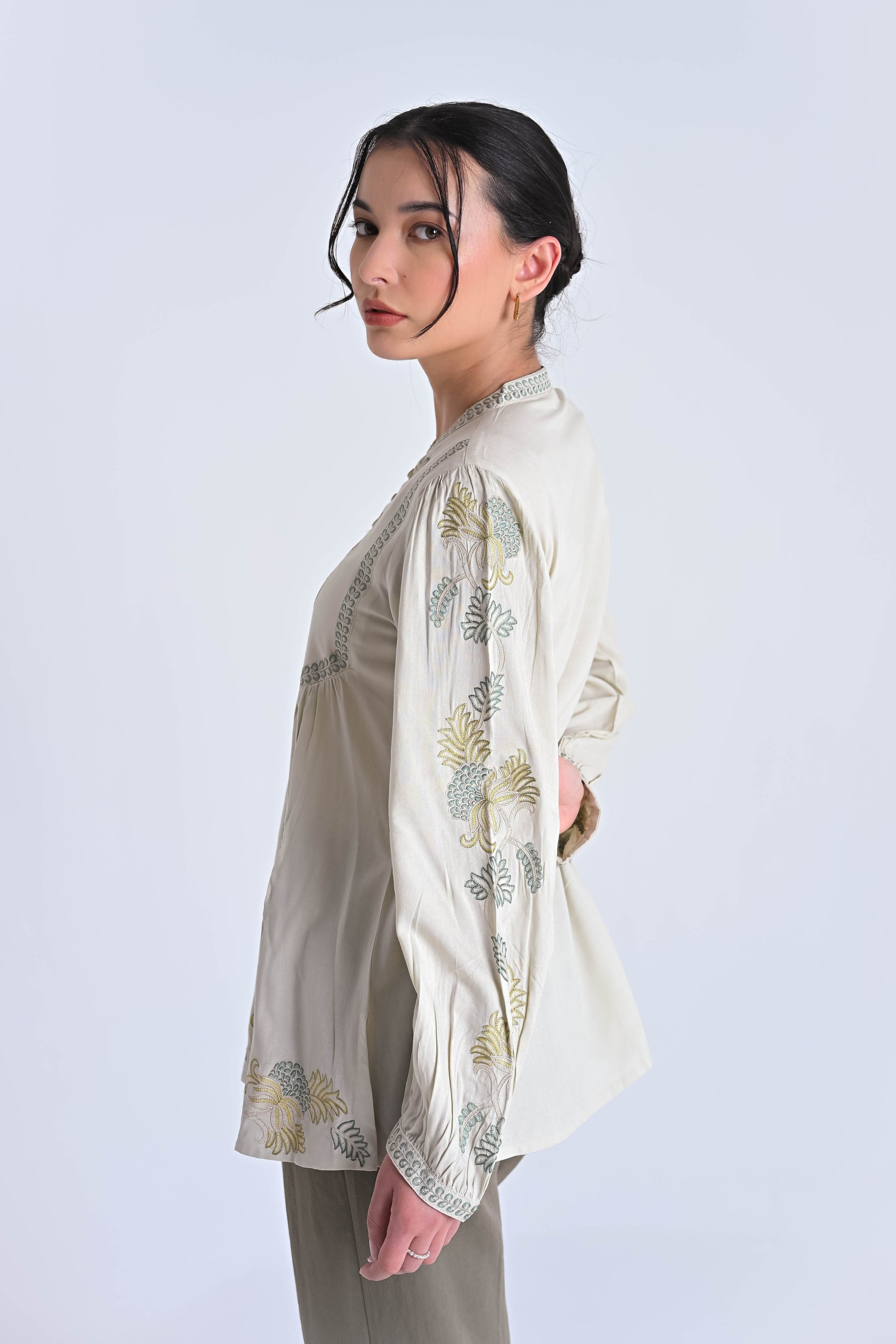 Model wearing an ivory indigrey Dahlia top with tonal pebblework embroidery on the sleeves and yoke.