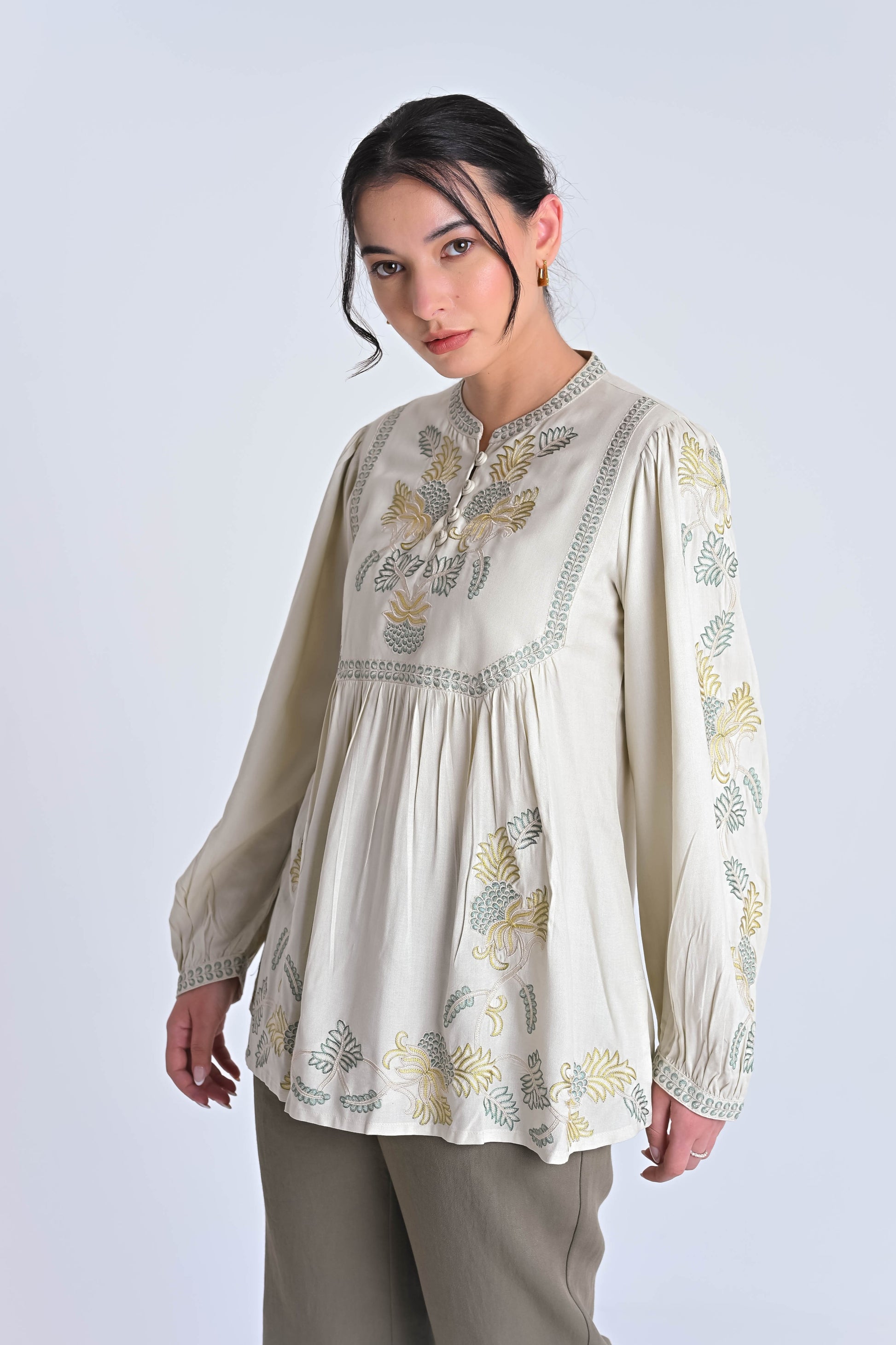 indigrey ivory Dahlia top with muted tonal pebblework embroidery on the yoke, sleeves, and hem, worn by a model.