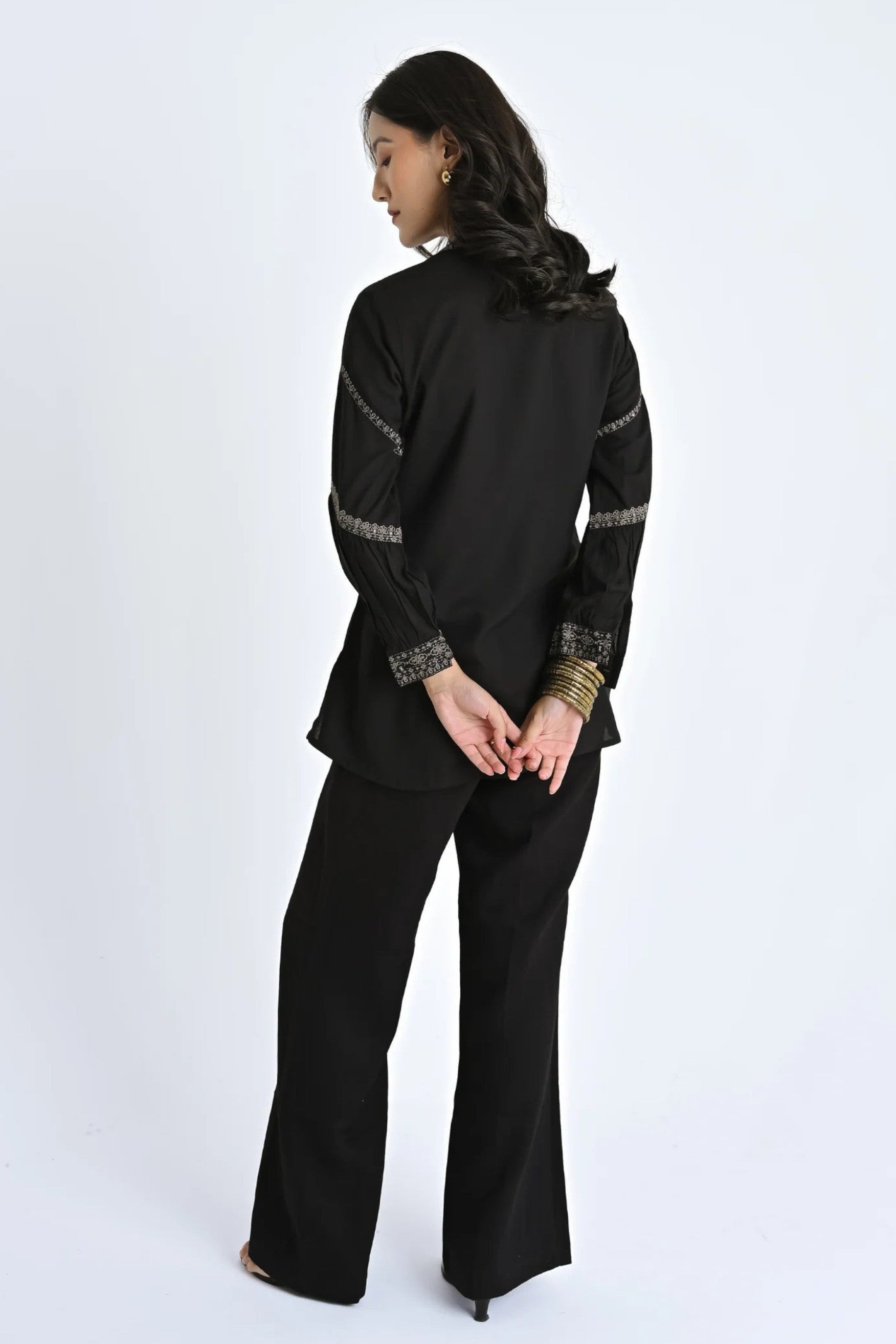 Model wearing black indigrey June top with filigree traceline floral embroidery on sleeves and cuffs