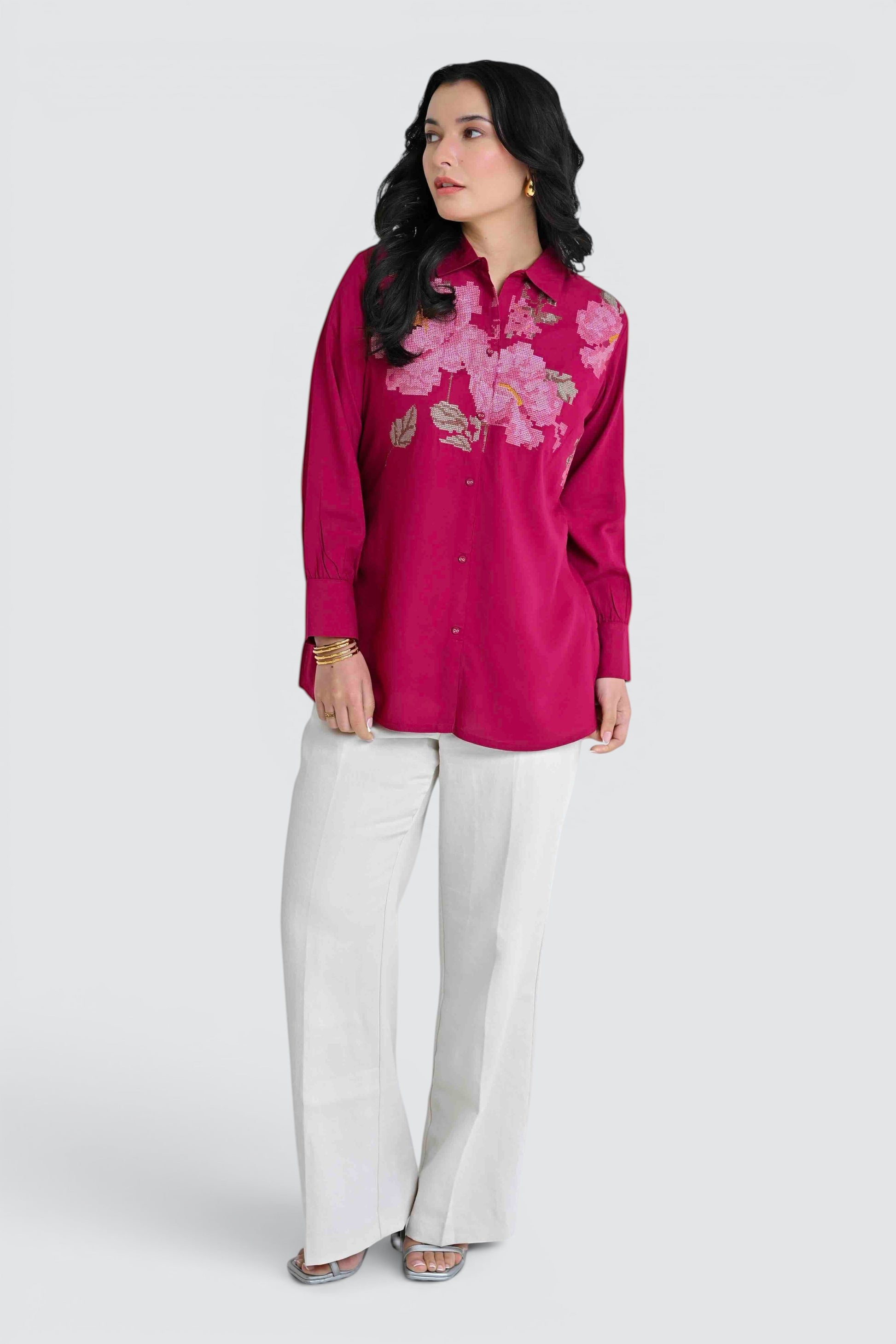 indigrey magenta long sleeve button down shirt with floral embroidery worn by a woman with white trousers