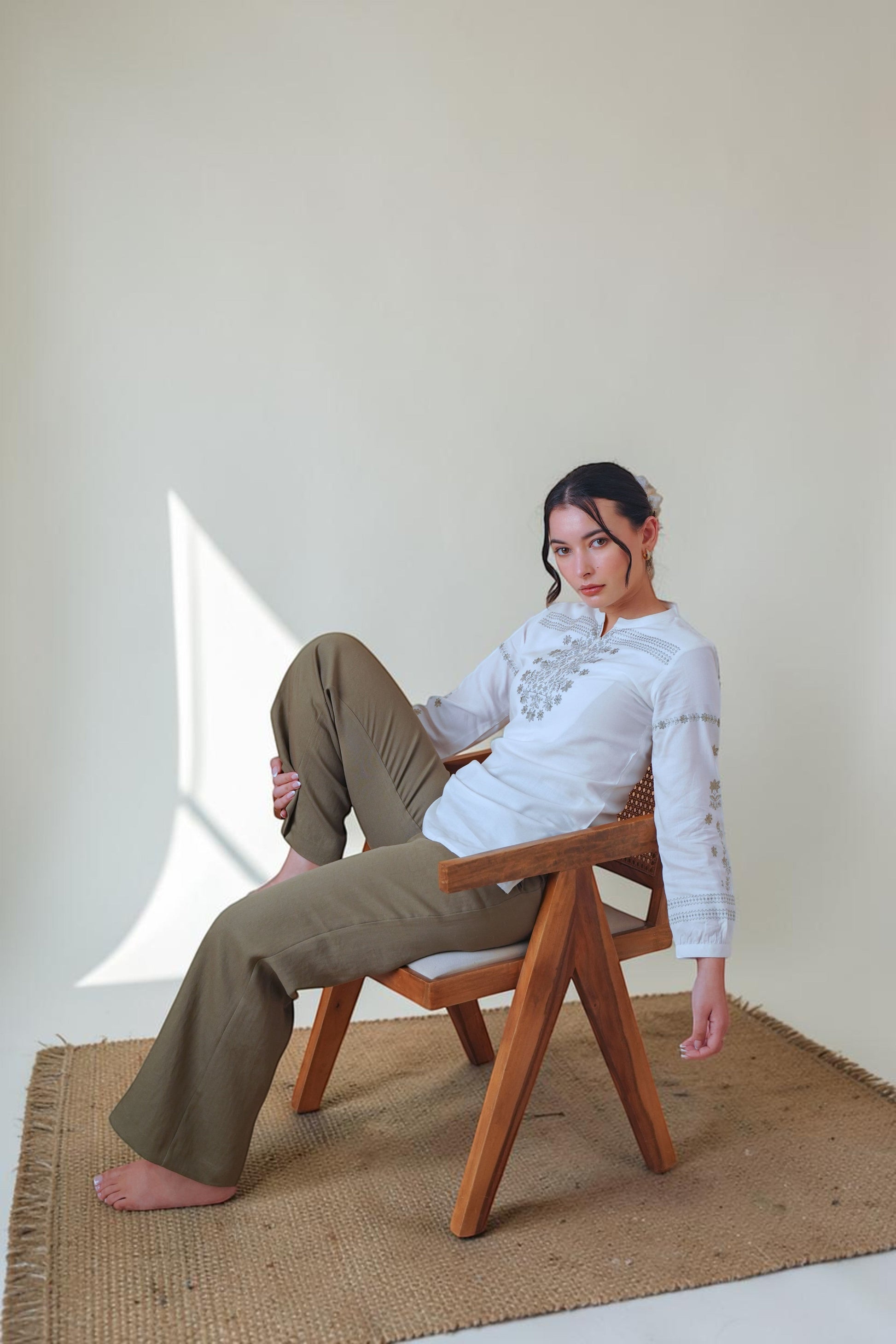 indigrey white Mosaic Embroidered top with floral latticework, long sleeves, and gathered cuffs worn by a seated model