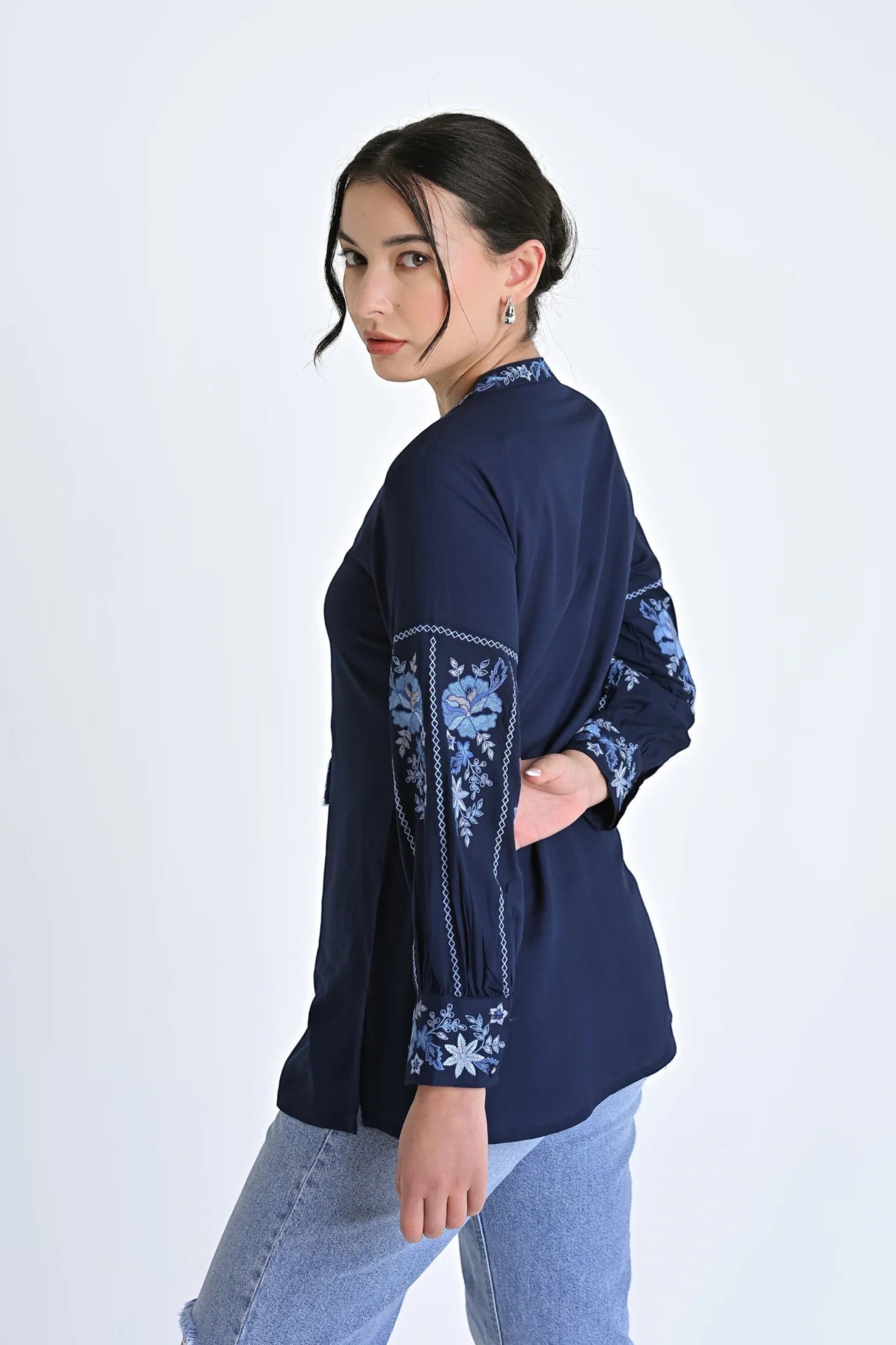 Model wearing indigrey navy Ivy shirt with light blue floral embroidery on sleeves and neckline