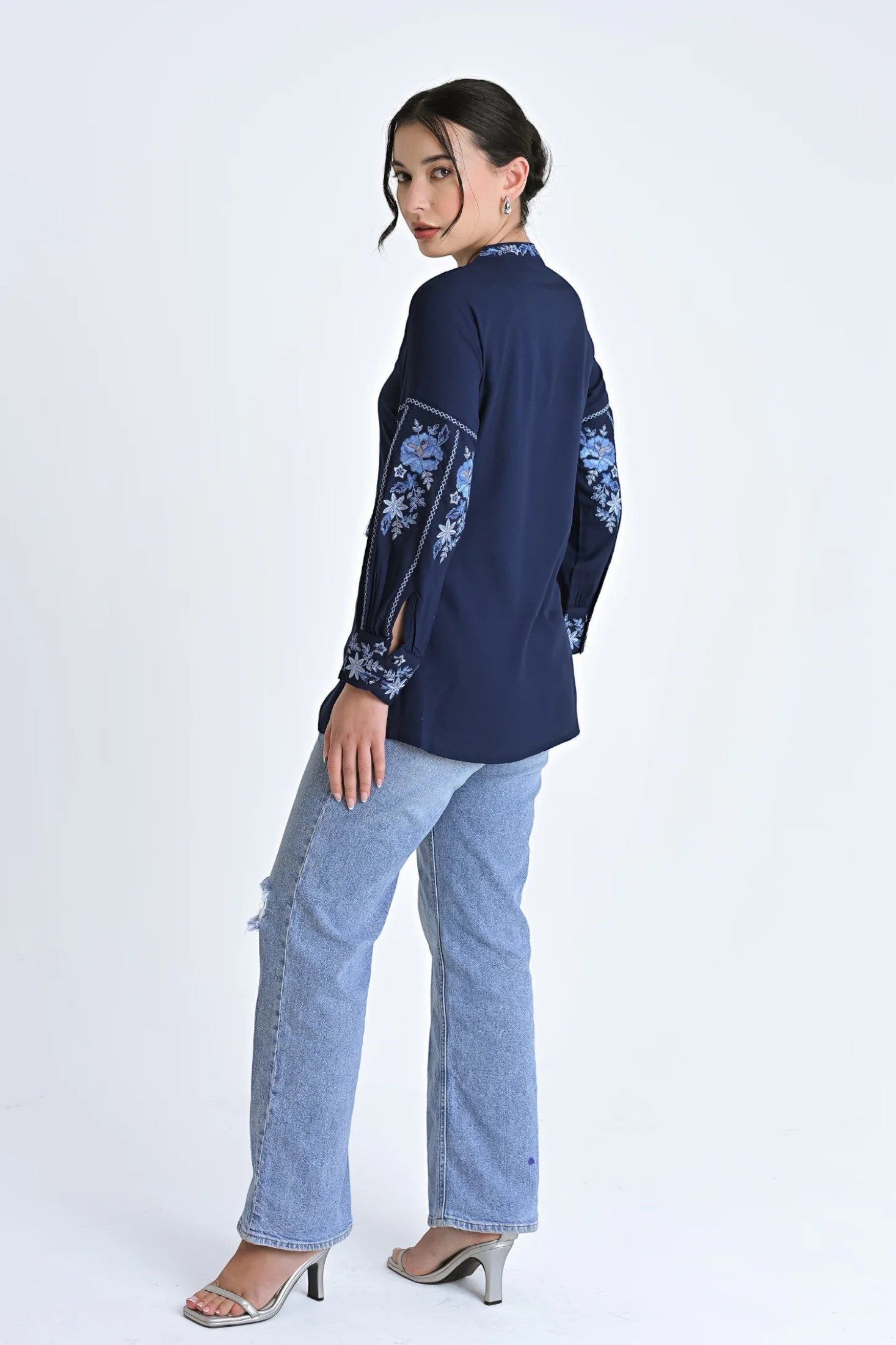 indigrey navy Ivy shirt with floral embroidery on sleeves and neckline, worn by a model with light wash jeans