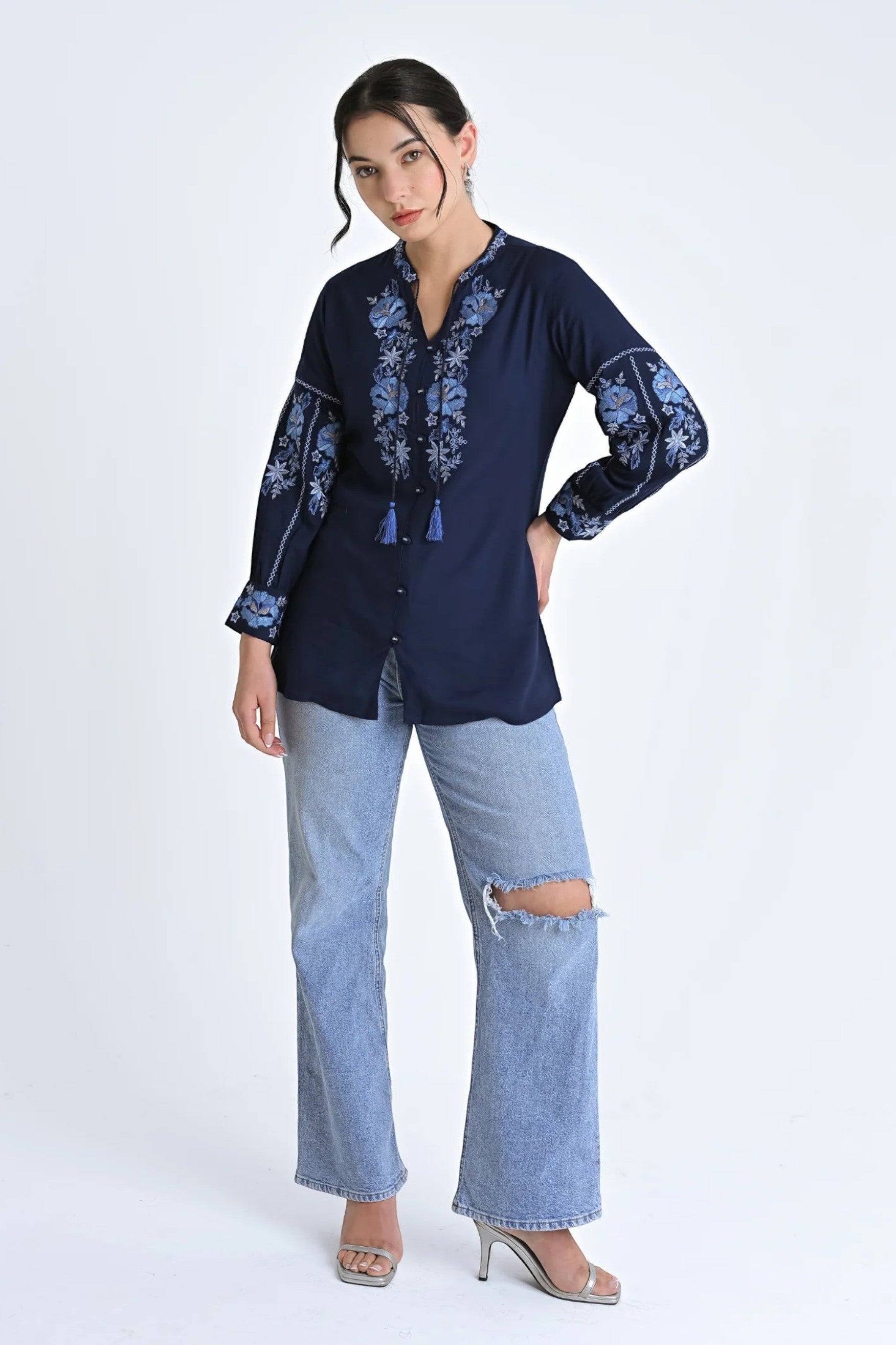 Model wearing indigrey navy Ivy shirt with light blue floral embroidery, tassel neckline, and long sleeves.