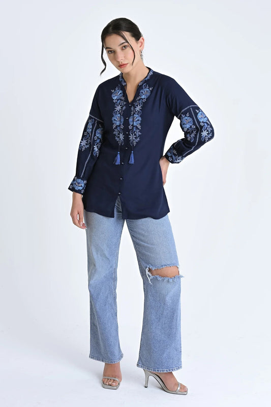 Model wearing indigrey navy Ivy shirt with light blue floral embroidery, tassel neckline, and long sleeves.