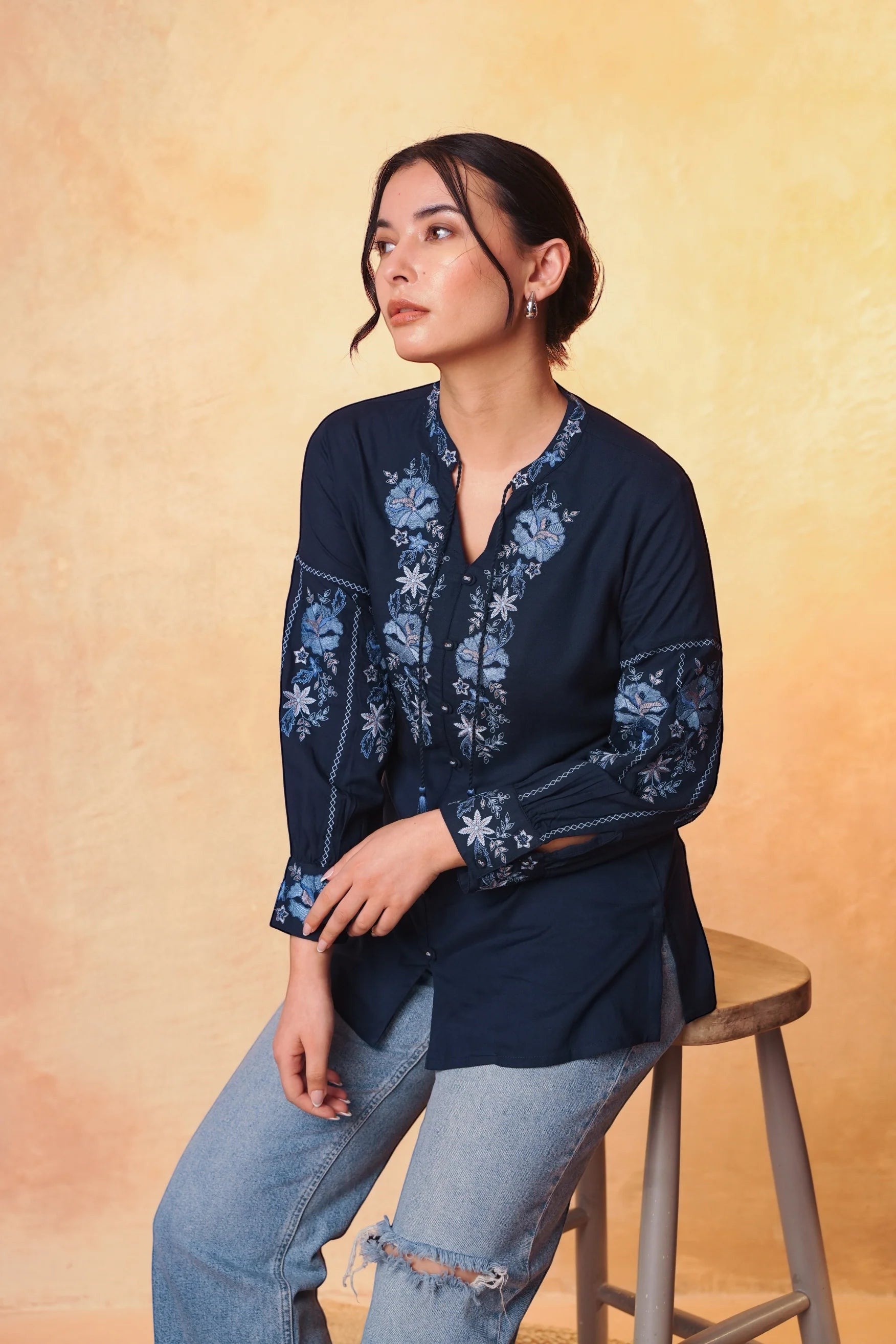 indigrey navy Ivy shirt with light blue floral embroidery on neckline and sleeves, featuring tassel details.
