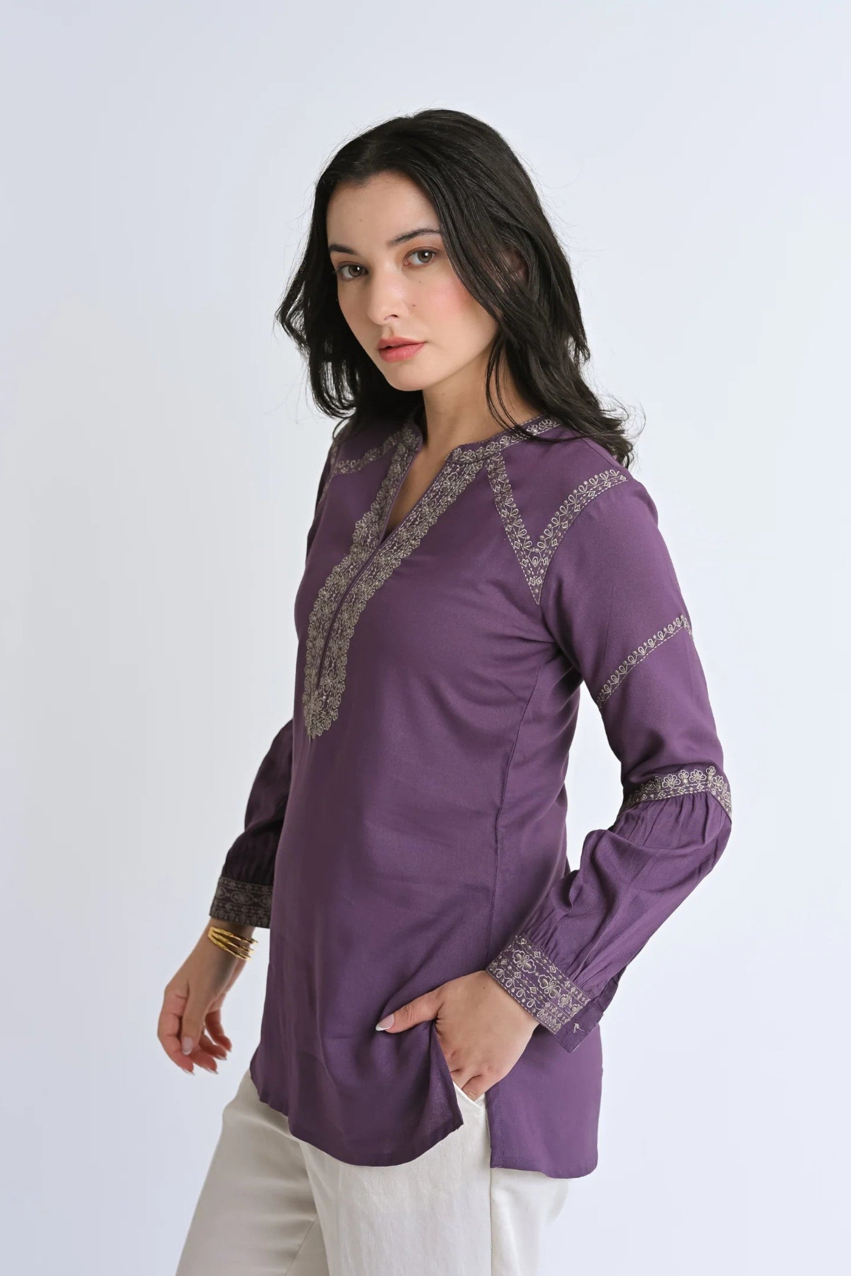 Woman wearing an indigrey purple June top with intricate tonal filigree traceline embroidery and long sleeves.