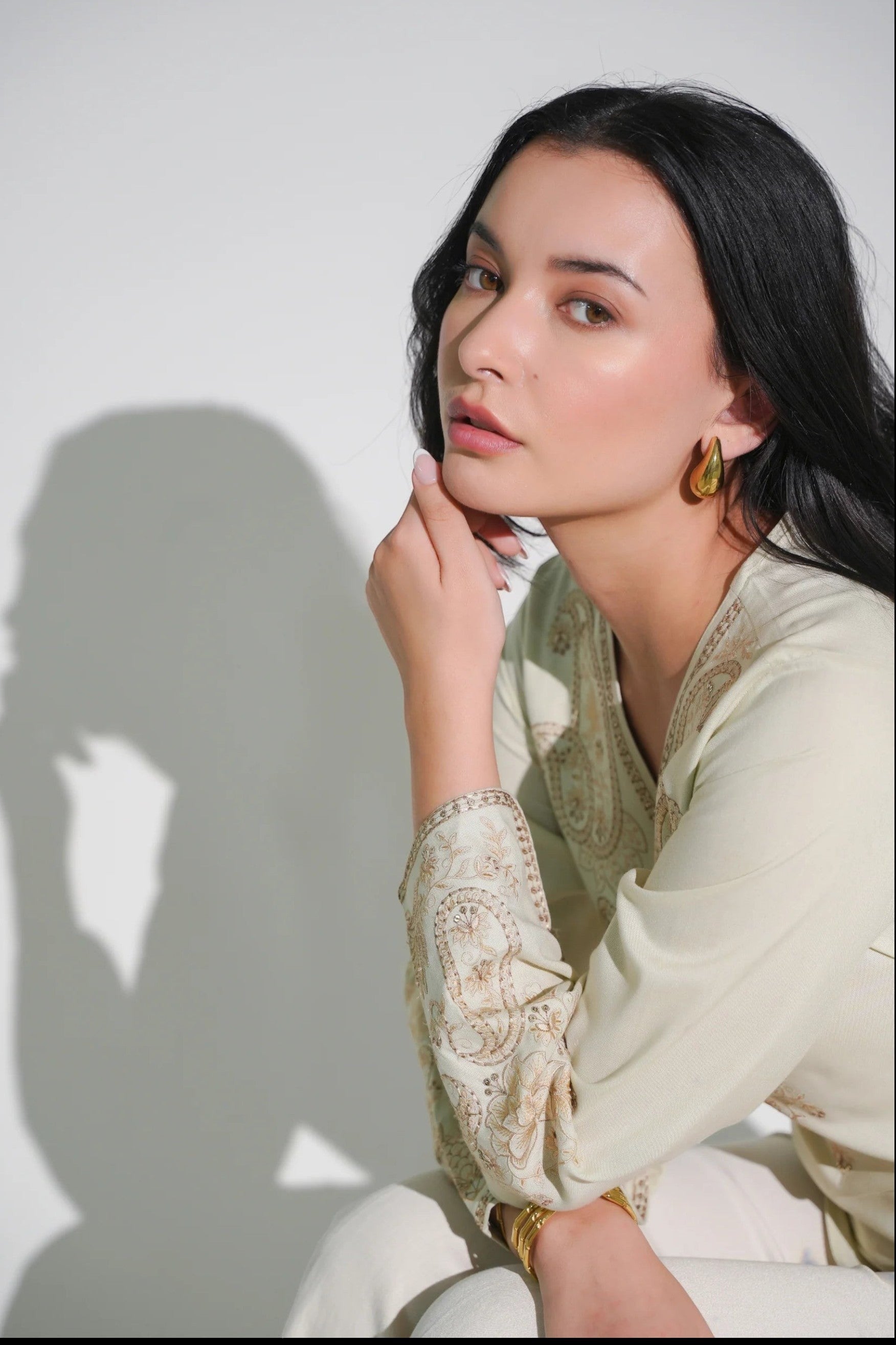 indigrey Raya ivory V-neck top with tonal corded stem fill embroidery and flared sleeves worn by a woman