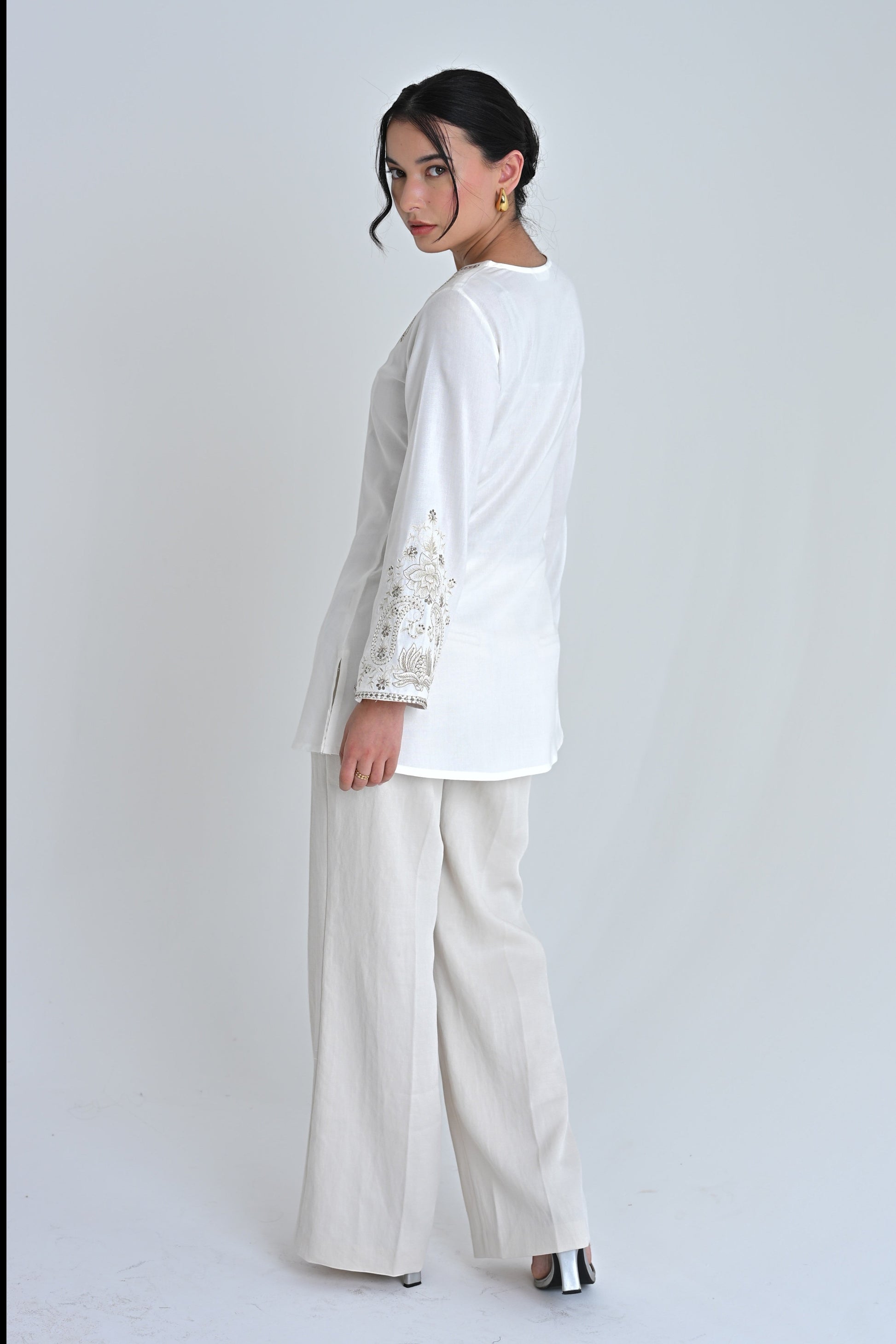 indigrey Raya white top with V-neck, flared sleeves, and corded stem fill embroidery worn by a model