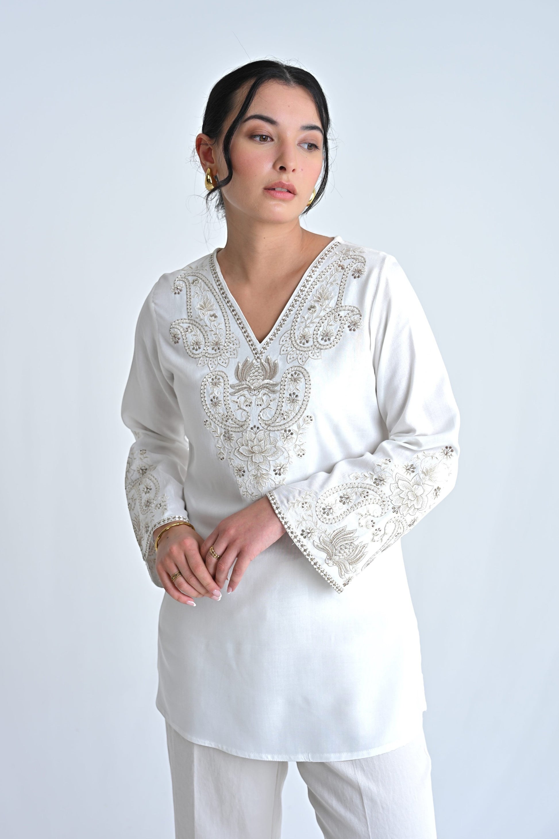 indigrey Raya white V-neck top featuring intricate corded stem fill embroidery and flared sleeves on a model.