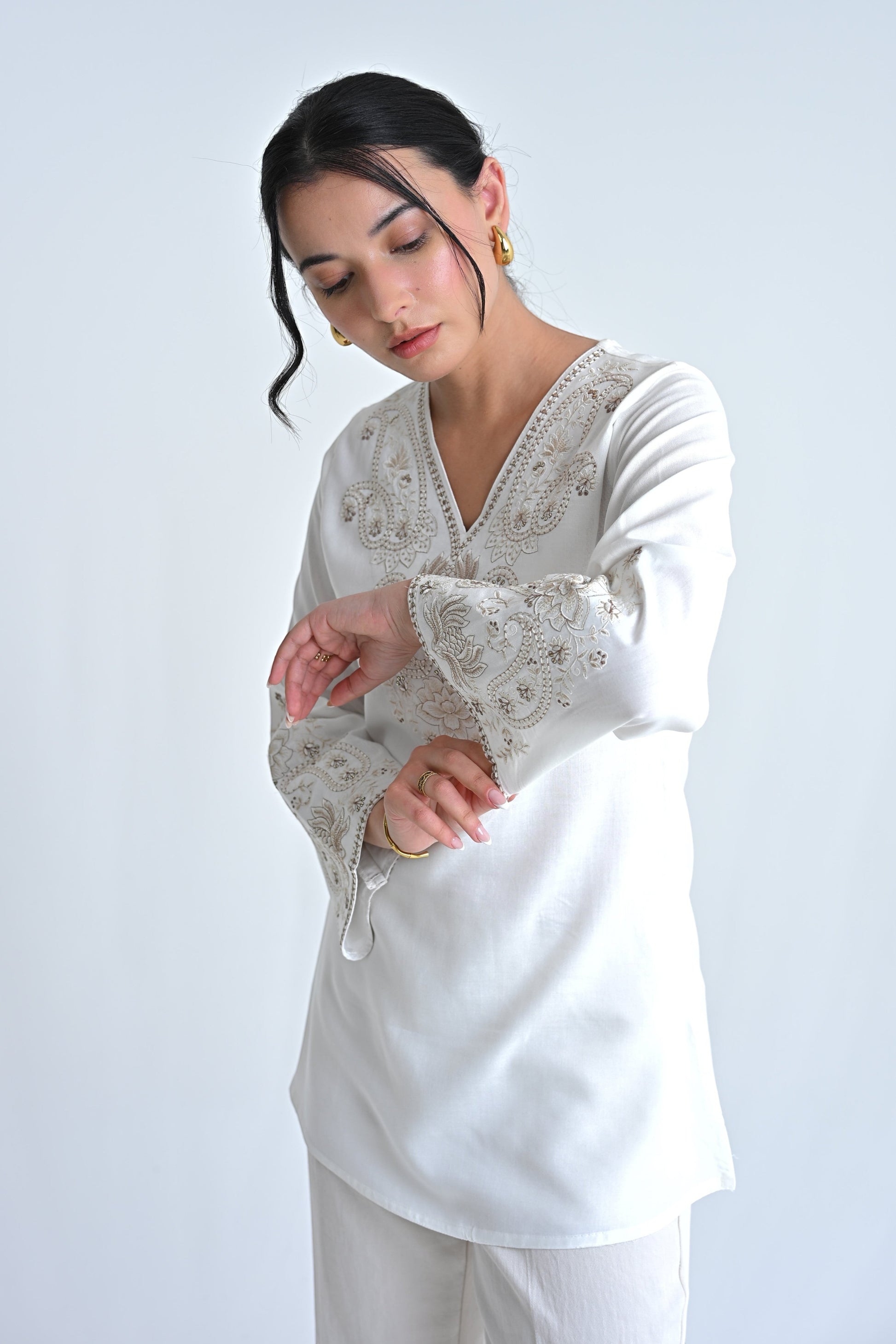 indigrey white Raya top with V-neck, flared sleeves, and intricate corded stem fill embroidery on chest and cuffs.