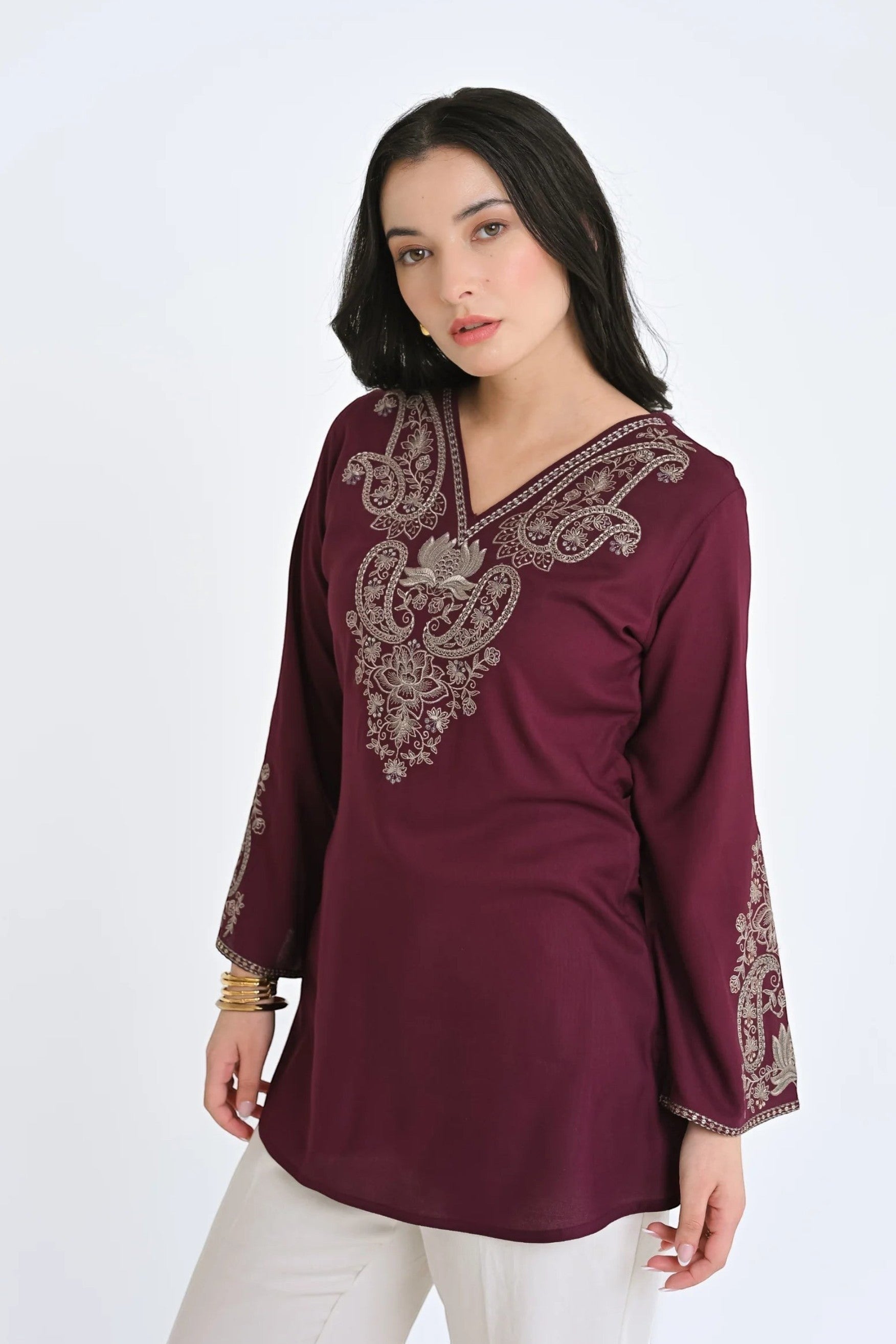 Model wearing an indigrey wine-colored Raya top with intricate tonal corded stem fill embroidery on the neckline.