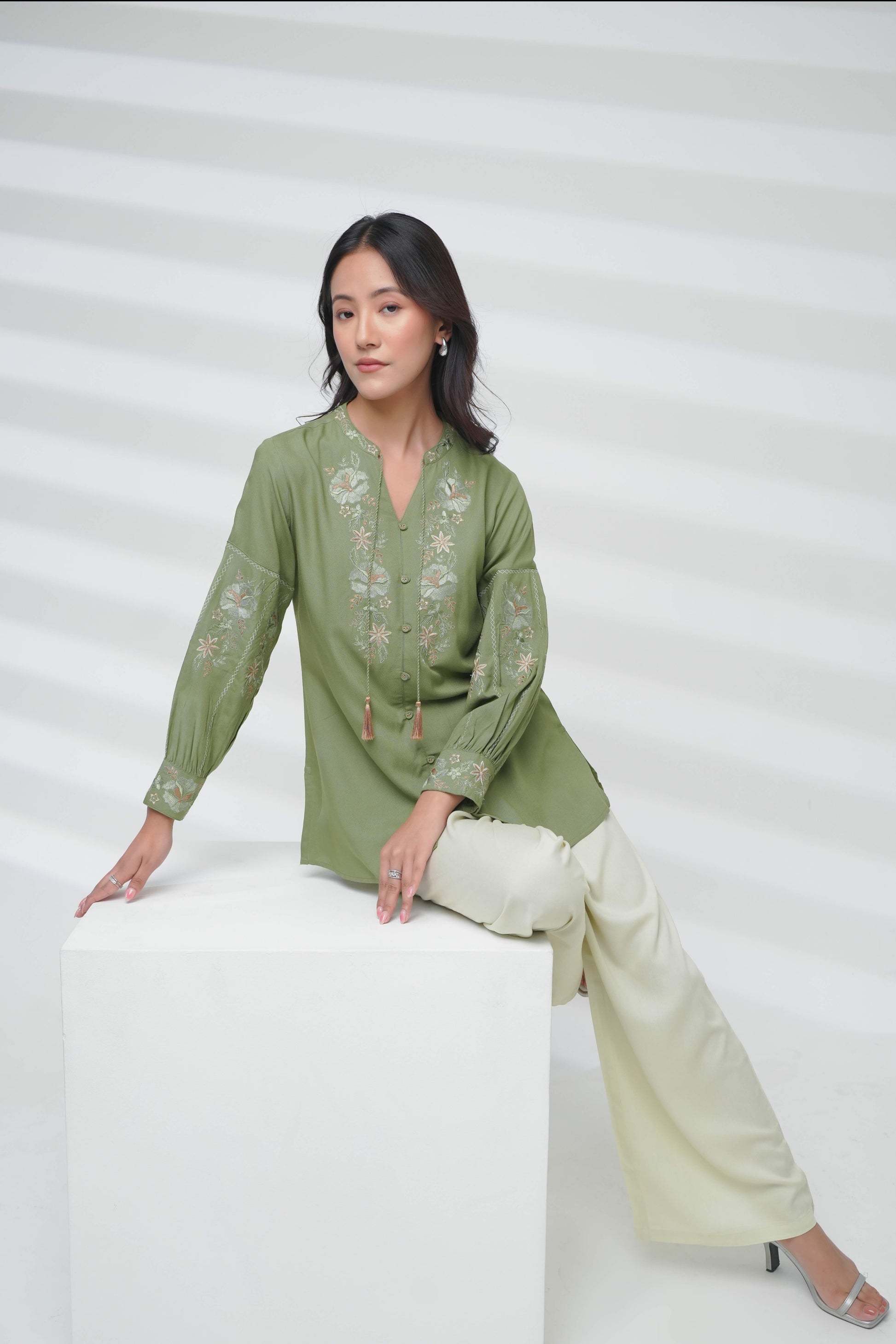indigrey sage Ivy shirt featuring floral fly brick stitch embroidery on the neckline and sleeves with tassel accents.