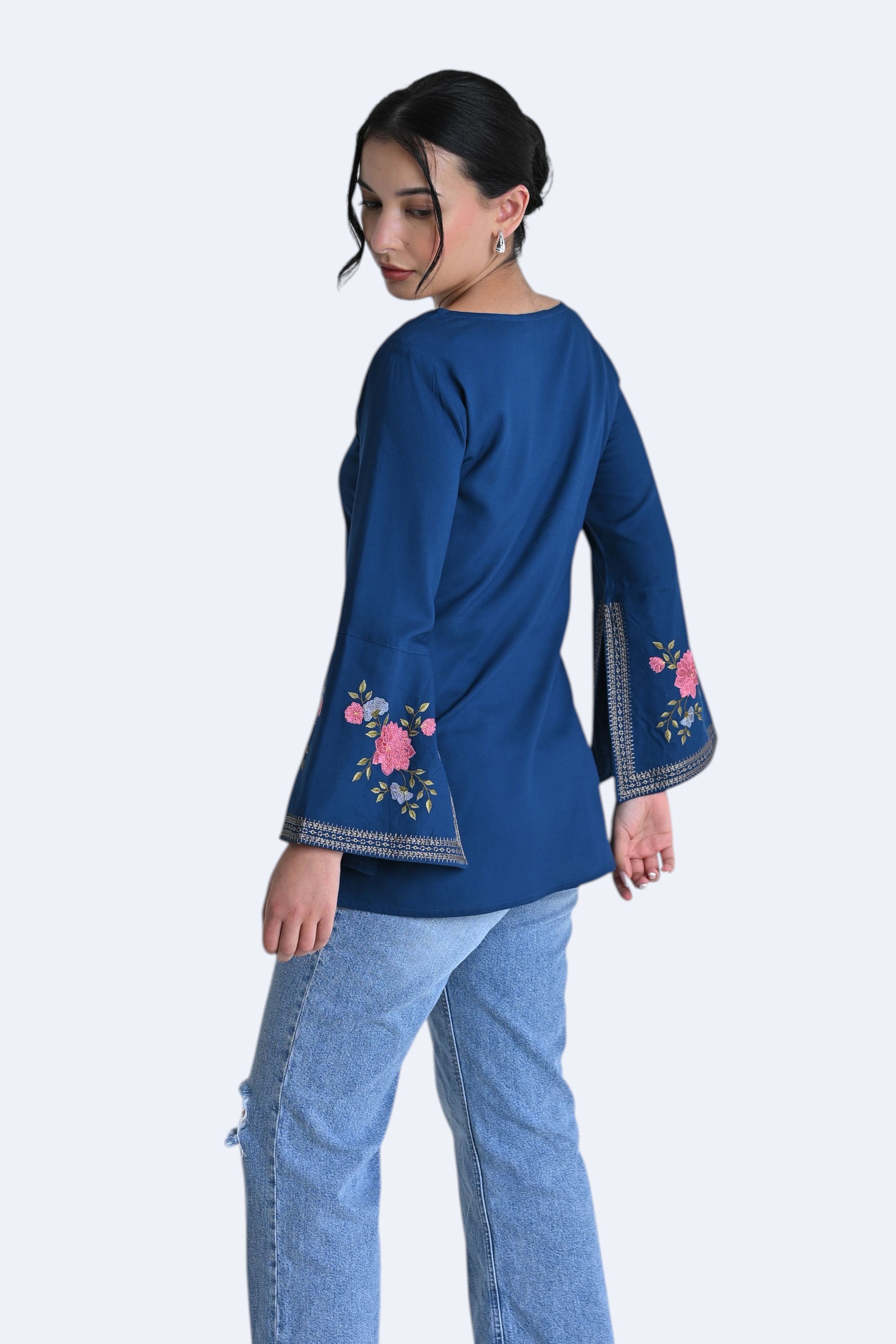 indigrey Zuri deep teal bell sleeve top with floral Sketchfill Cord embroidery on sleeves worn by a model