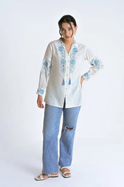 indigrey white shirt with blue floral fly brick stitch embroidery, tassel details, and long sleeves on a model