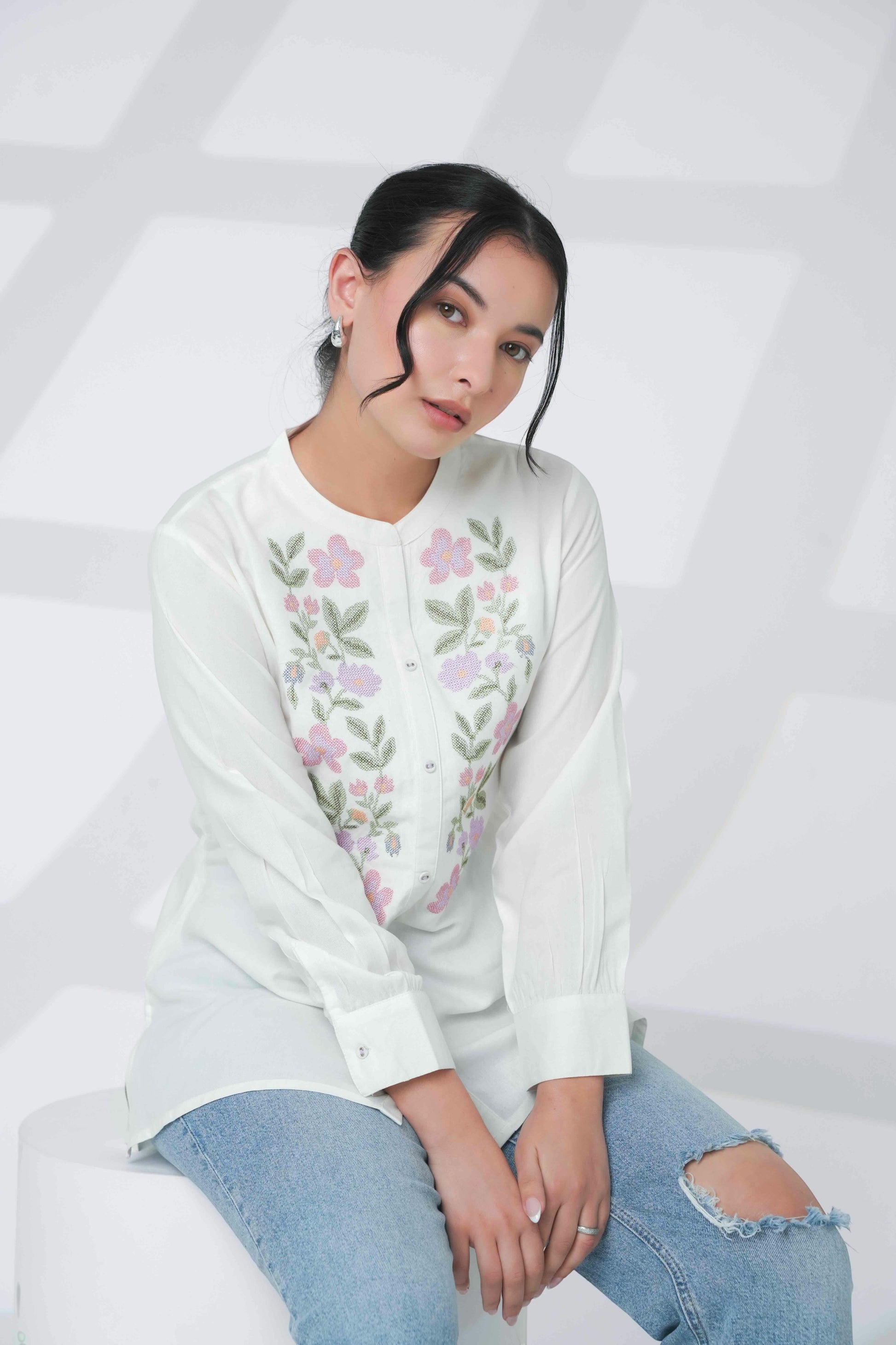 Model wearing an indigrey white shirt with handcrafted floral cross stitch embroidery and long sleeves