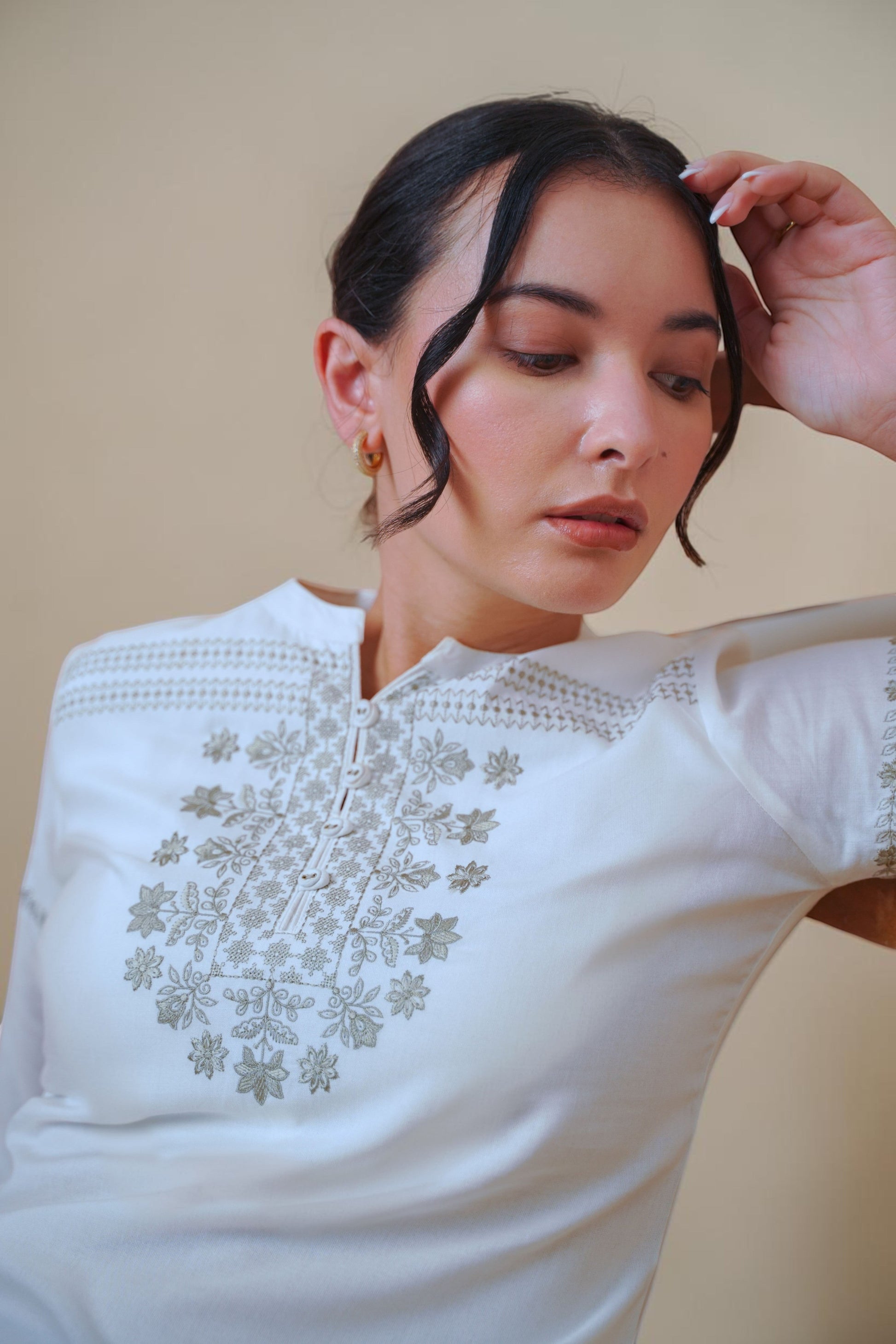 indigrey white top with intricate floral latticework embroidery on the neckline and shoulders, worn by a model