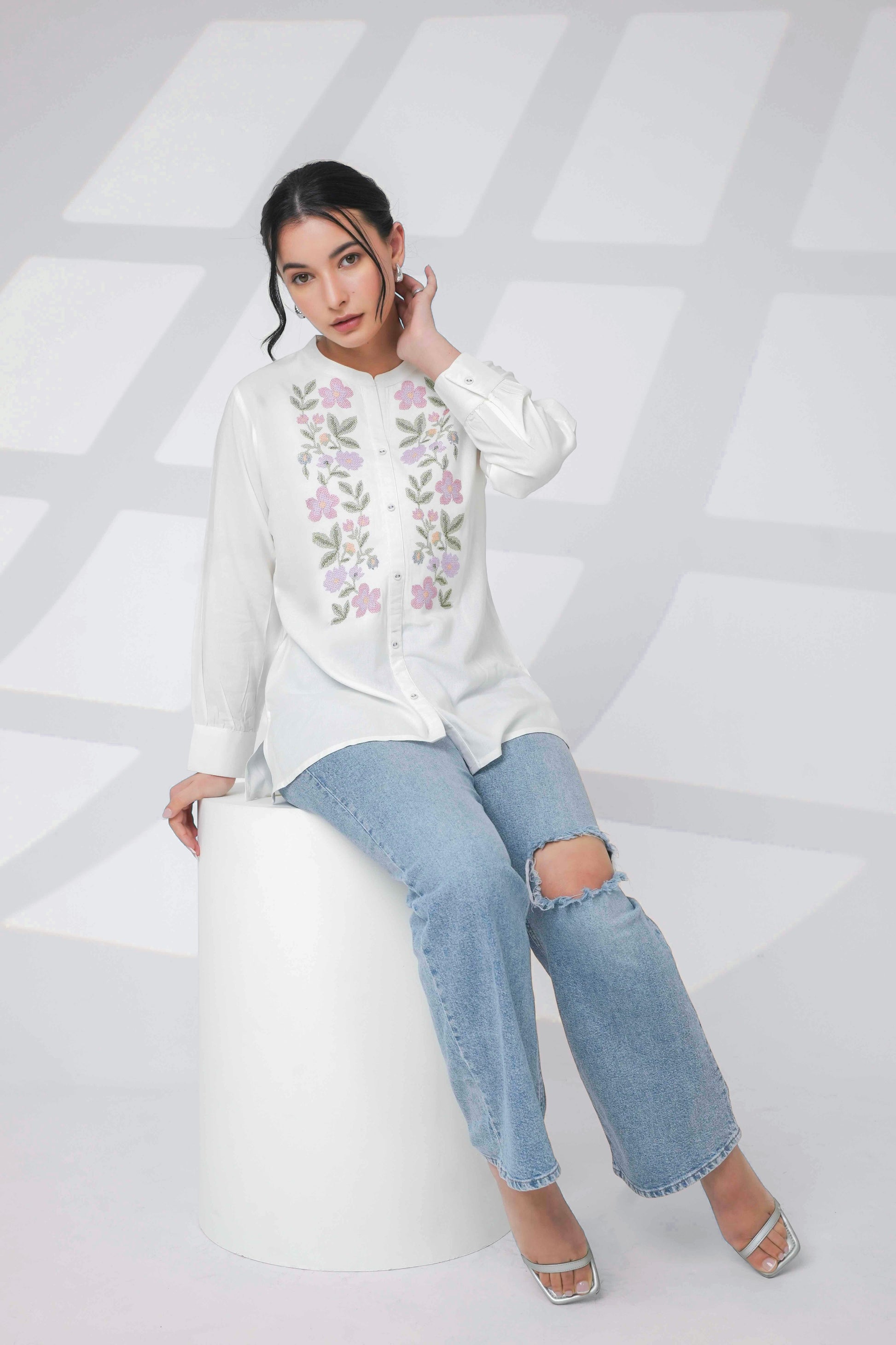 indigrey white shirt with delicate floral cross stitch embroidery worn by a model with light wash distressed jeans