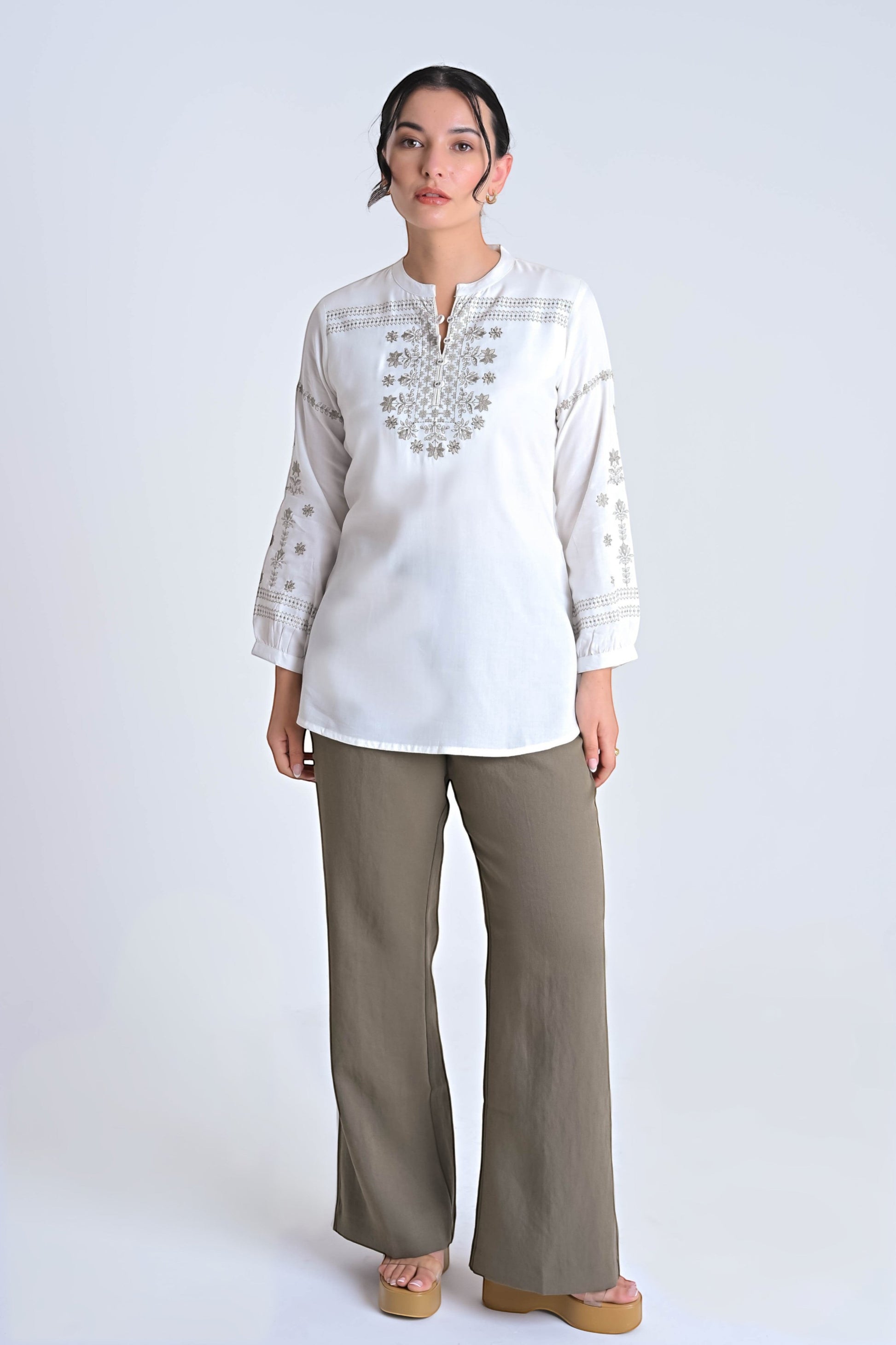 Model wearing an indigrey white top with intricate grey floral embroidery, long sleeves, and a relaxed straight fit.