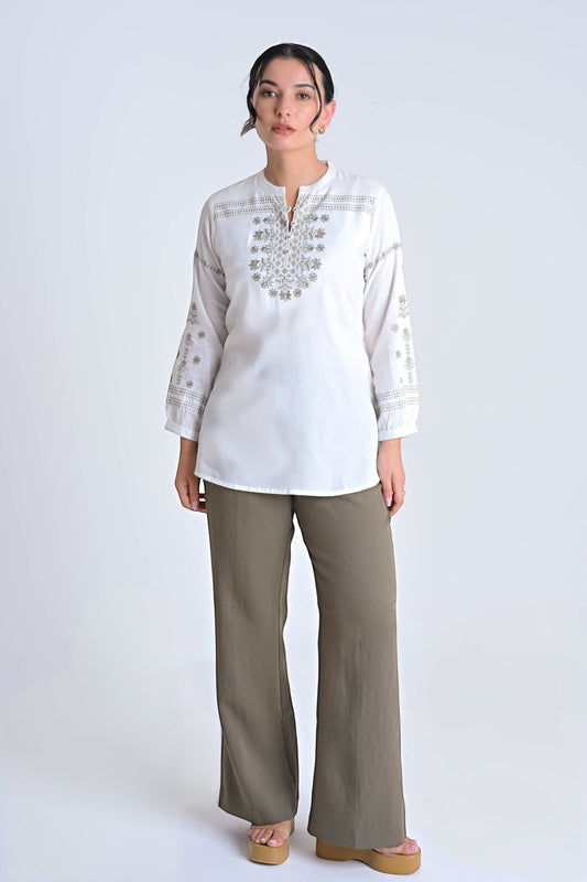 Model wearing an indigrey white top with intricate grey floral embroidery, long sleeves, and a relaxed straight fit.