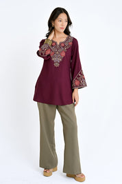 Model wearing an indigrey wine-colored Ambi embroidered top with floral paisley motifs and full sleeves.