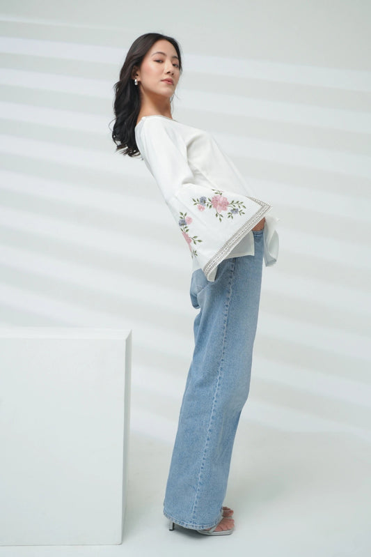 Model wearing indigrey white Zuri top with floral Sketchfill Cord embroidery and flared bell sleeves